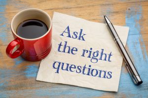 Ask the right questions - handwriting on a napkin with a cup of espresso coffee